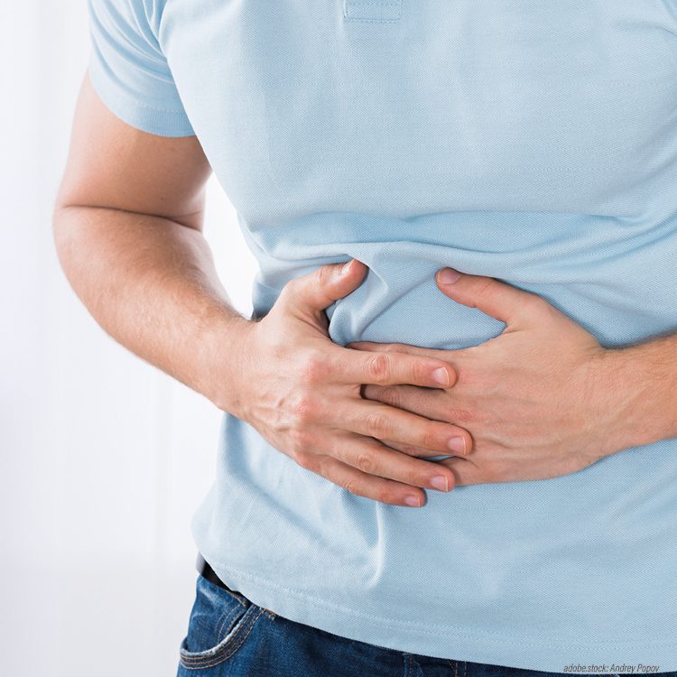 im Ausschnitt gezeigte, männliche Person hält sich den schmerzenden Bauch