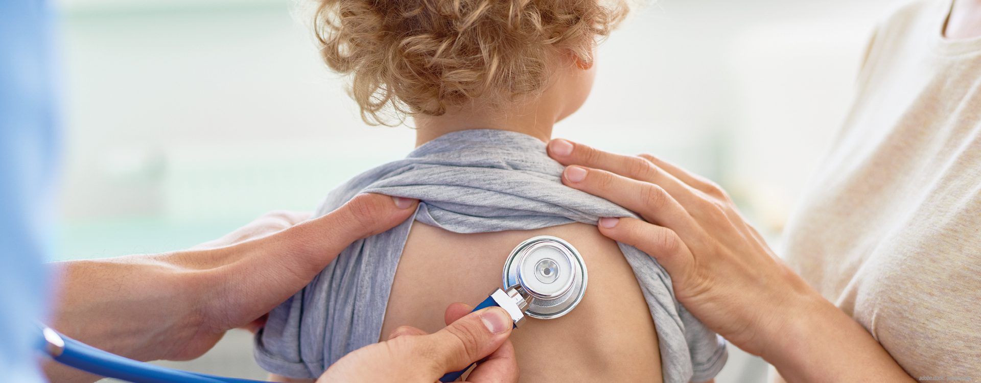 etwa dreijähriges Kind wird am Rücken mit einem Stetoskop abgehört.